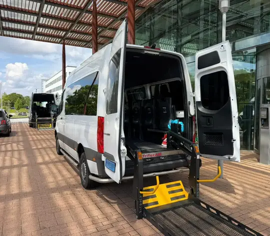 Professionele rolstoeltaxi chauffeur helpt klant in Scheveningen